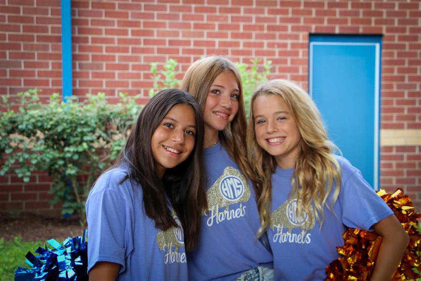 Three students smile